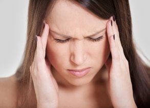 woman holding head pain headache migraine